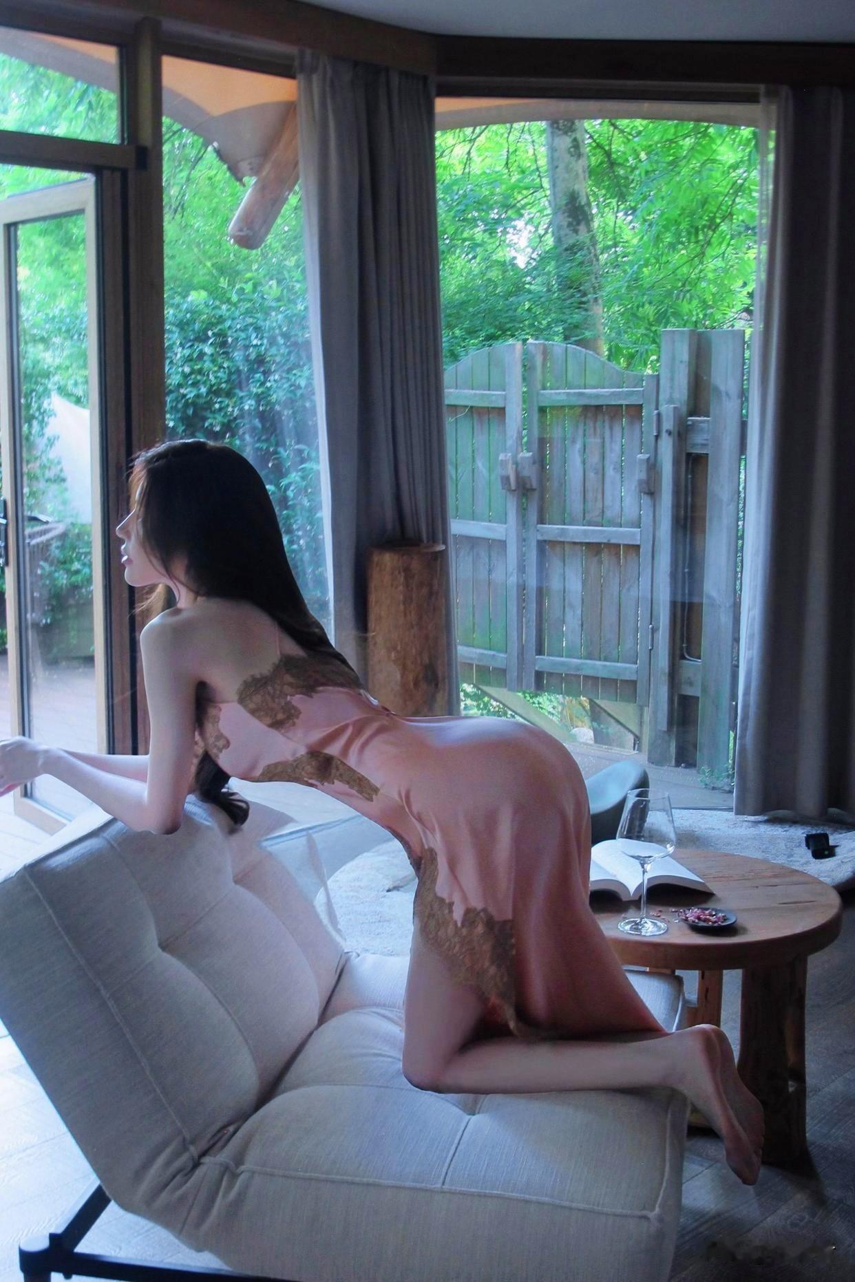 她眉眼温婉气质恬静，纤瘦身形被这袭粉色蕾丝长裙妥帖包裹。

精致蕾丝面料自带肌理