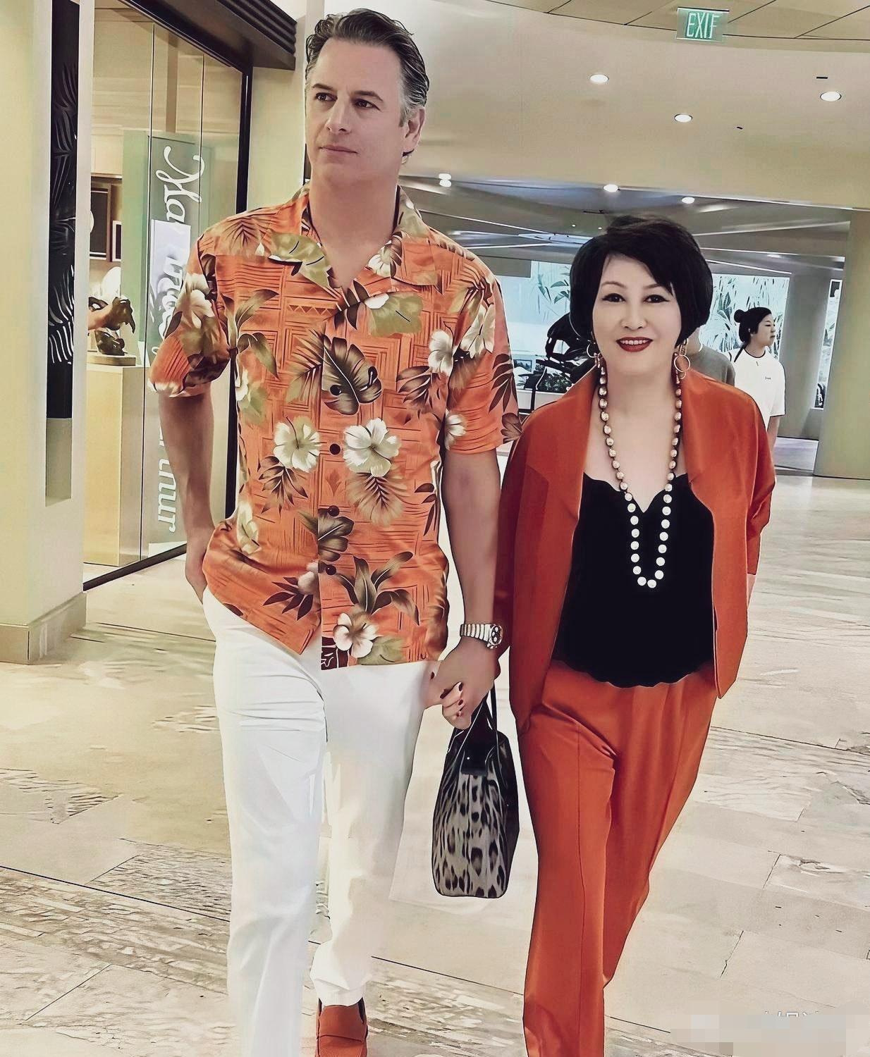 时尚界的鼻祖靳羽西与小15岁的西班牙男友艾伦，在商场牵手漫步抓拍。二人十指紧扣，