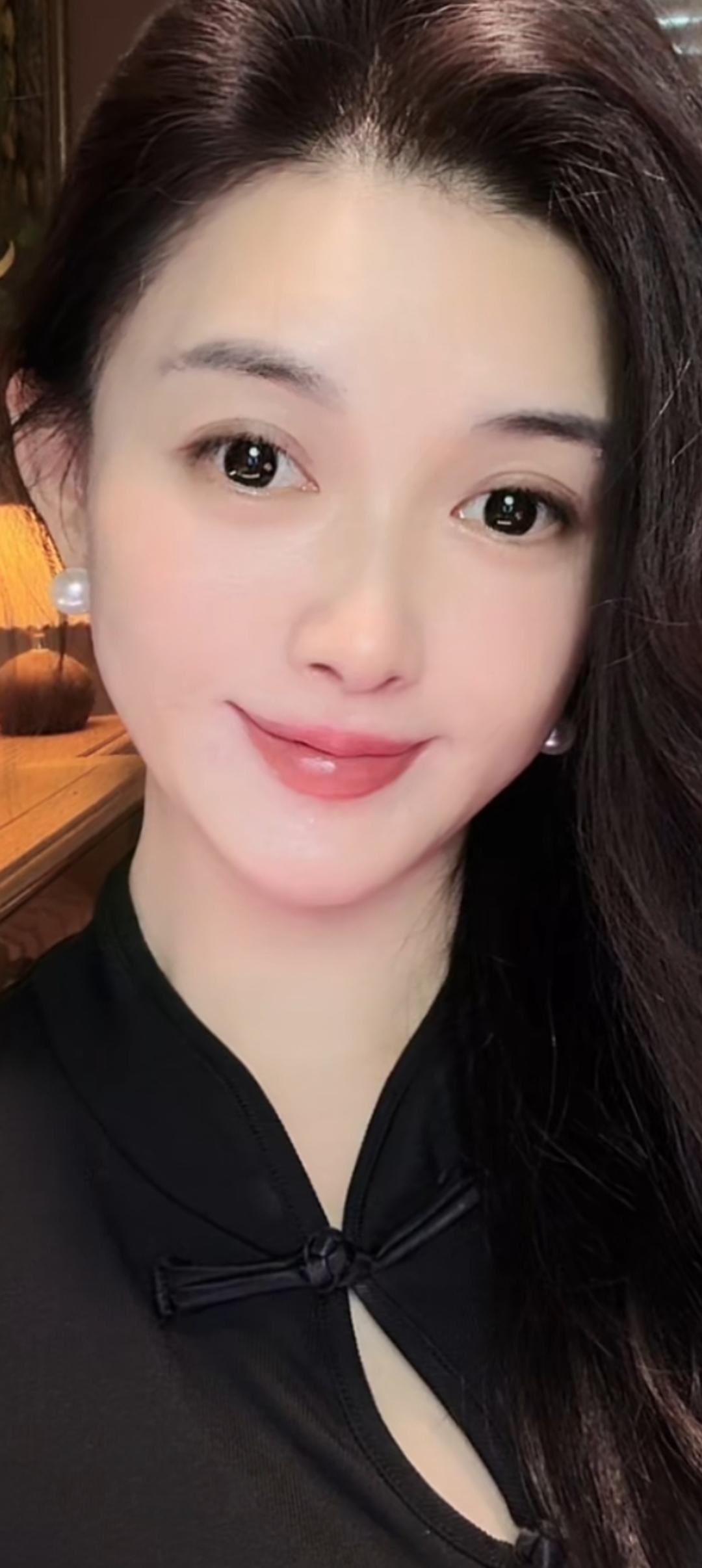 微笑的姑娘，穿黑色上衣。