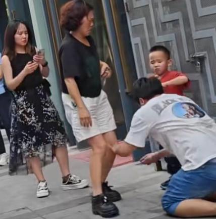 南京街头，一男子跪在水泥地上，向劈 腿老婆连磕三个响头，哭喊：“我一天打两份工，