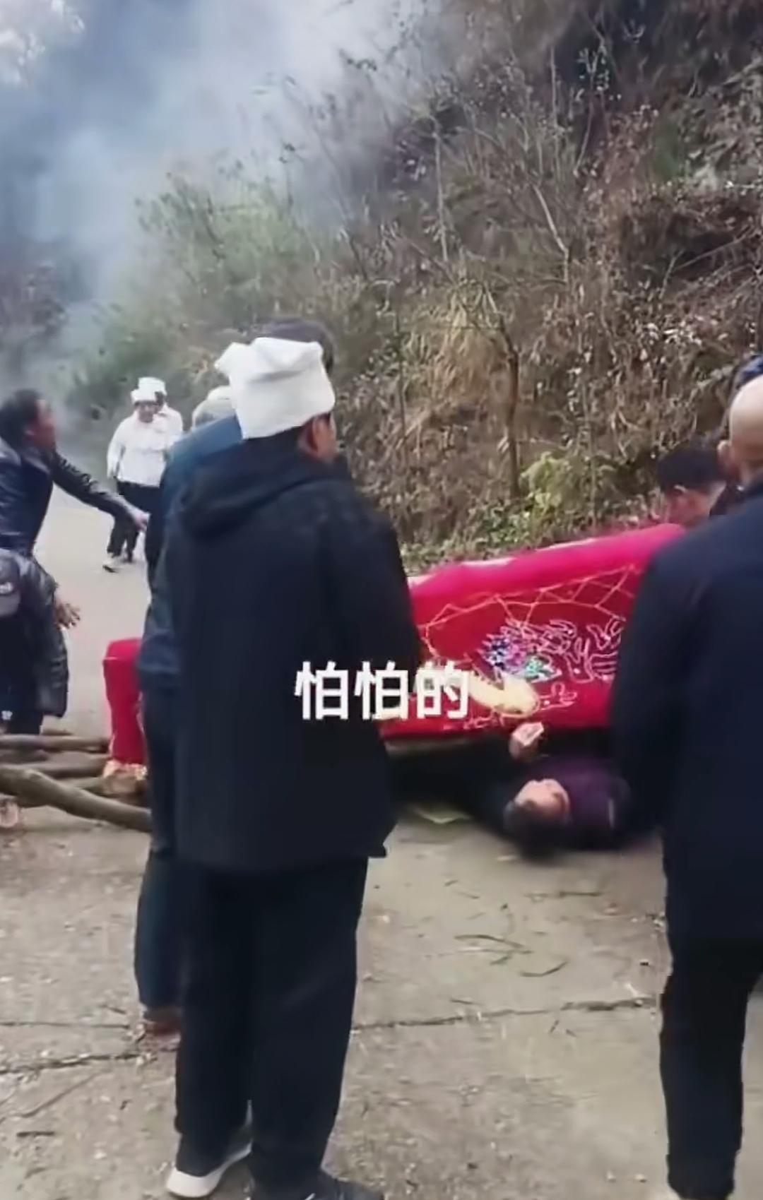老人离世，众人抬着棺材还没出村歇脚，便出现了摔棺的状况。有两名村民直接被棺材压在