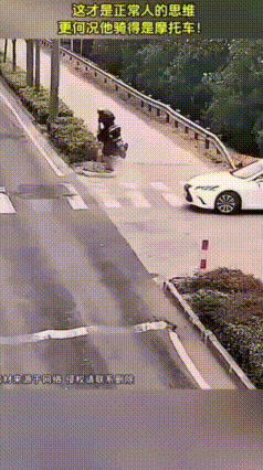 路口岔道处，一辆白色小车正要拐进主路。这时一名小哥骑着摩托车车速有点快，看到白车
