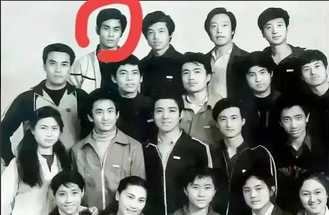 看看这张老照片啊，站在后面那个小伙子，你们能认出是谁吗？他的名字你们应该都很熟悉