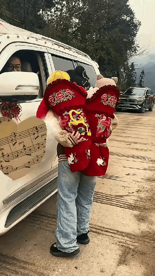 在云南的山水间，一幅温馨又充满趣味的画面悄然上演。一位年轻的女子，背着一对龙凤胎