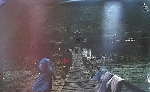 1914年7月3日，泸定桥，并非后世加固的样貌，数根黝黑的铁链横架在湍急的河面（