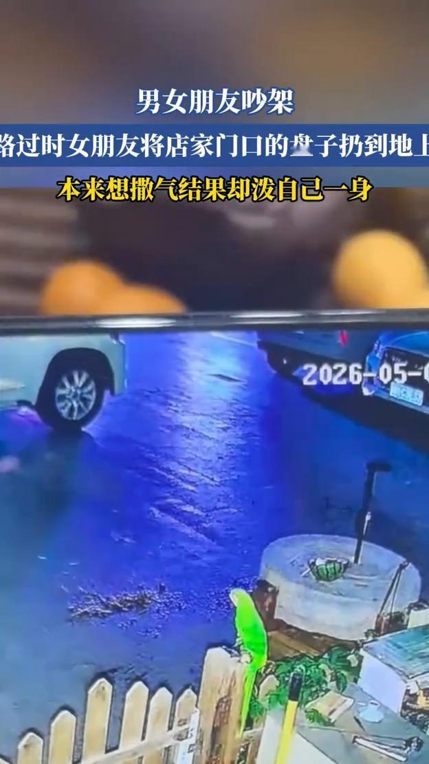 男女朋友吵架，路过时女朋友将店家门口的盘子扔到地上，本来想撒气结果却泼自己一身。