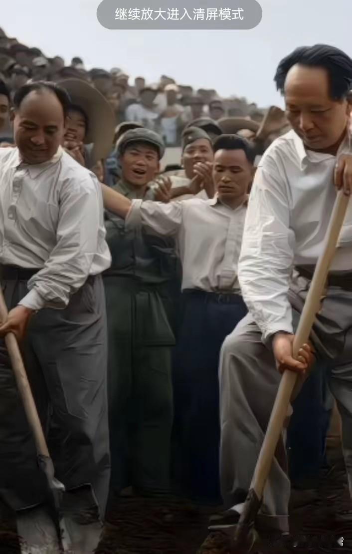 毛主席亲临工地参加劳动，手持铁锹躬身挖土，与群众一同参与建设劳作。身后围观的百姓
