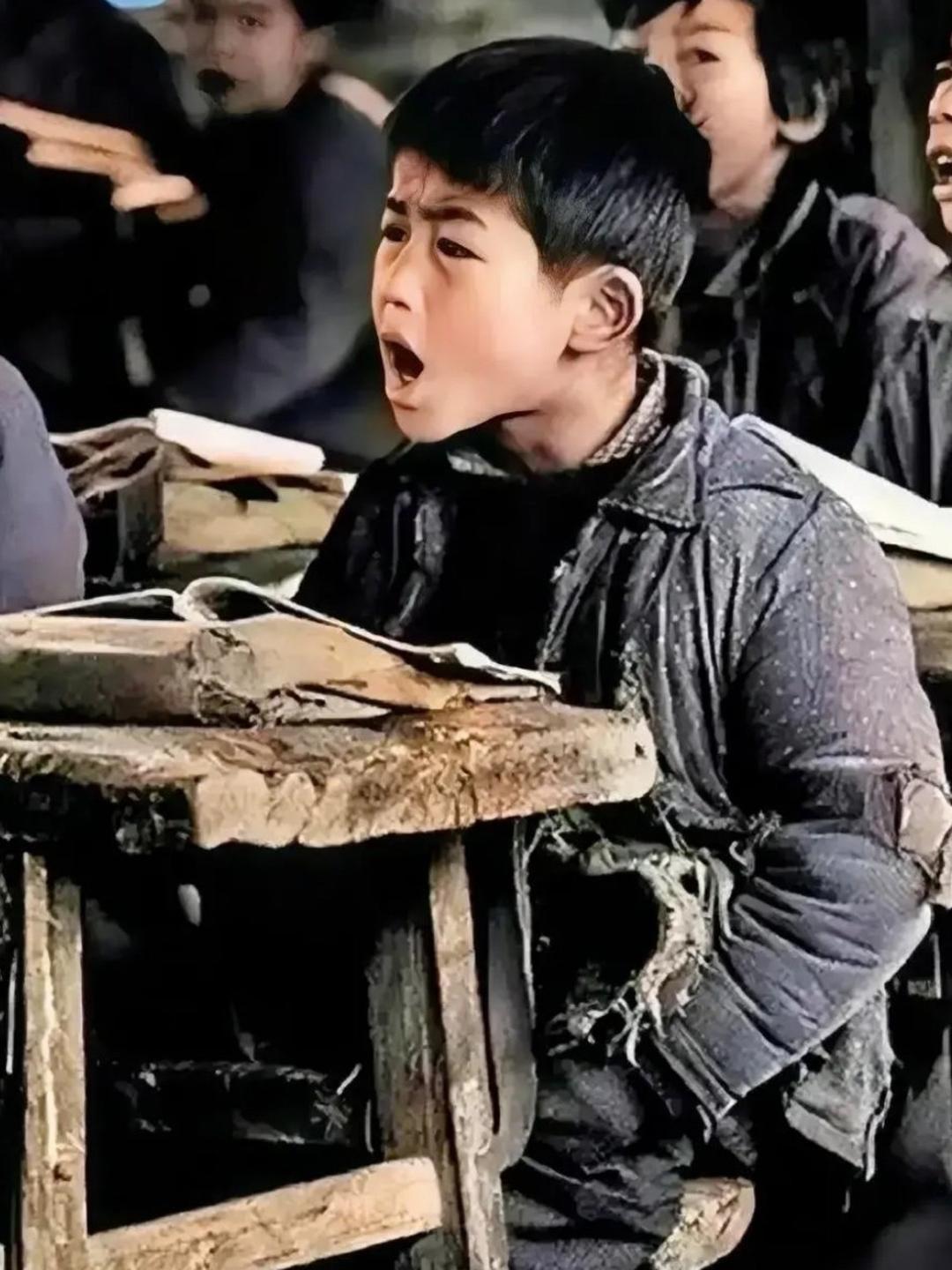 1991年，湖北红安，一所山村小学内，一个男孩坐在课桌前大声地跟着老师念书。

