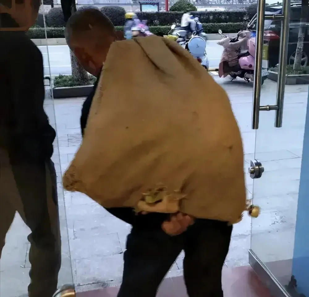 这位衣着简陋背着麻袋的老人推开了宠物医院的门，人们投来惊讶的目光，麻袋里是一只生
