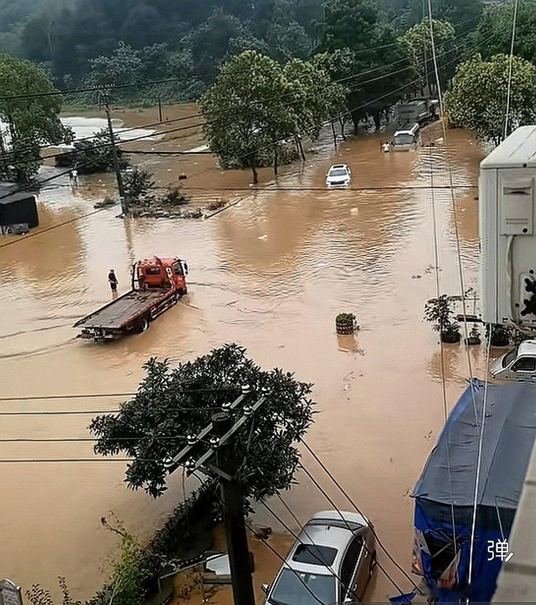 中国大陆重庆市城市科技学院（永川校区），永川暴雨积水路面可别乱走，红车过去了，对