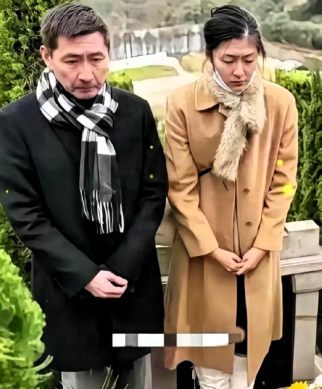 那张照片，让人看了心里一紧。 
​​张子健带着女儿张依依，站在李婷的墓碑前。
