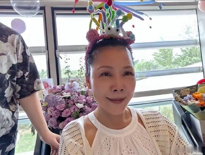 田震北京庆59岁生日，茅台相伴，收六束花。穿挂脖长裙显洋气，竟与那英有几分神似，
