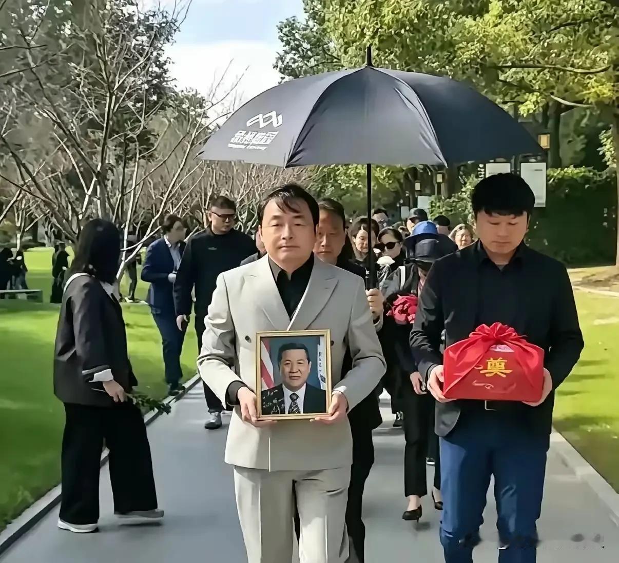 这是李昌钰博士在扬州的追思安葬现场，落叶归根的这一刻，画面肃穆，满是离愁。捧着遗