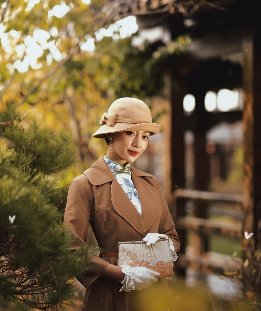 这位女士穿着复古风，优雅地站在户外。