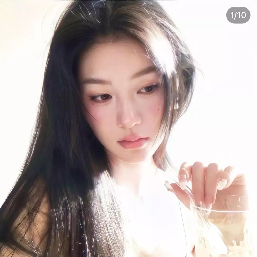 温柔的光线洒下，少女凝视手中的玻璃杯，梦幻而宁静。自然光下少女 少女眸光 咖啡杯