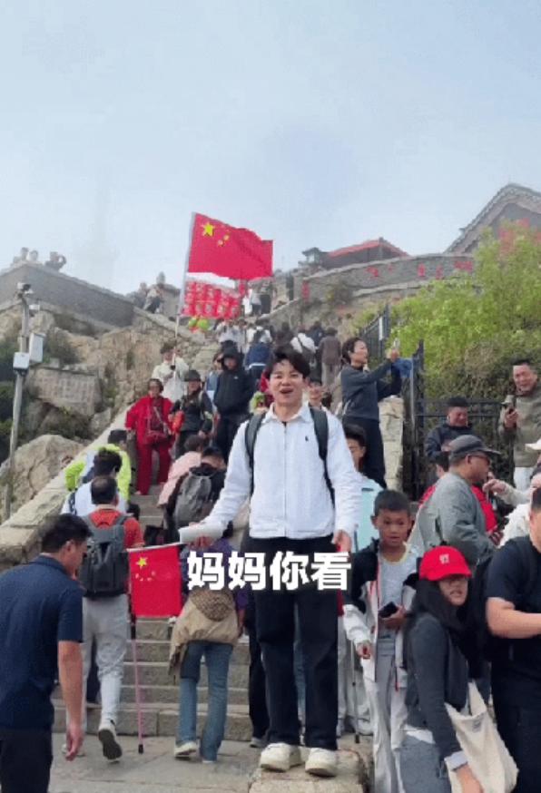 “太戳心了！”国庆节当天早上，山东泰安的泰山顶上，人群里一个小伙子举着五星红旗，