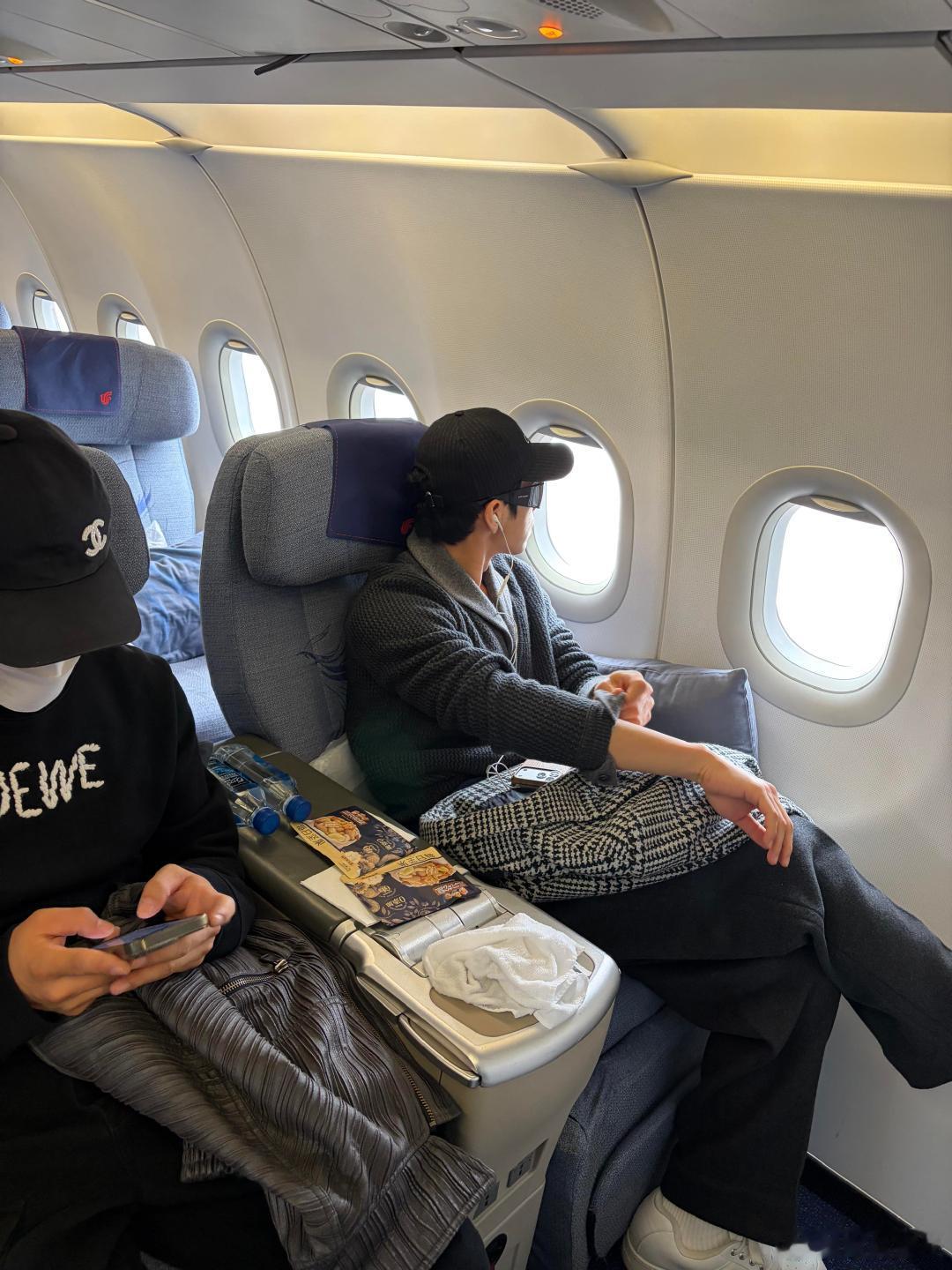 飞机上偶遇井柏然，他戴帽子墨镜侧对着窗，手搭在袖口上，侧脸轮廓利落又舒展 
