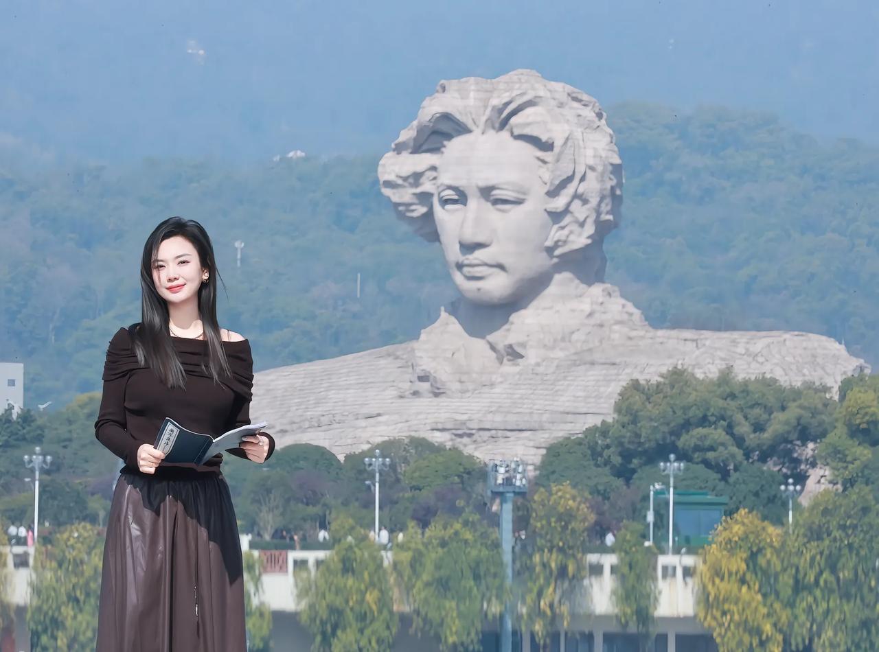 一个女孩在雕像前看书，风景很美。