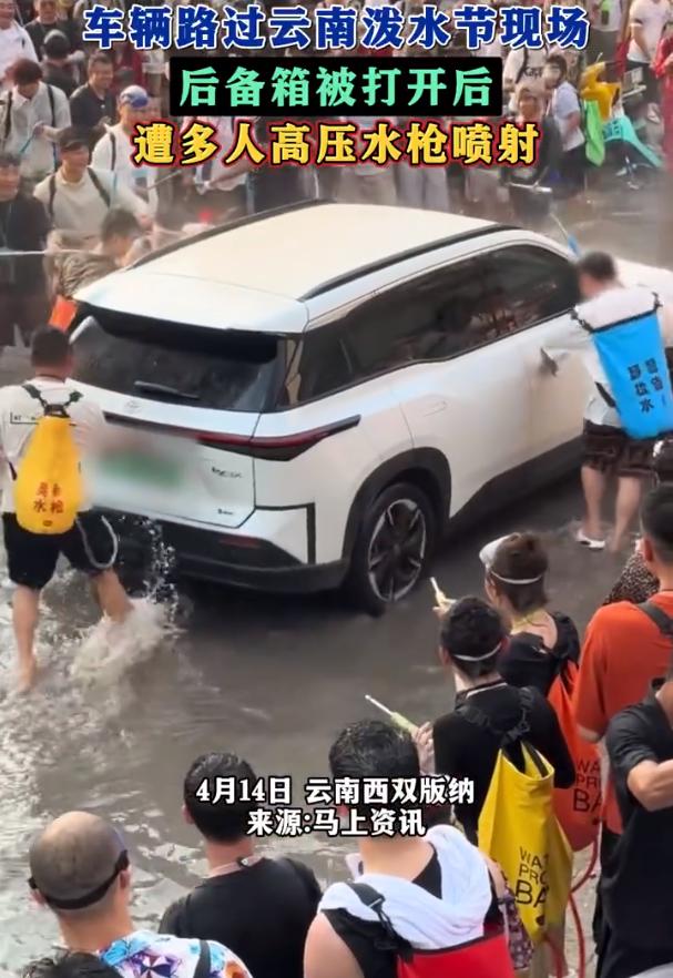 泼水节图的是开心热闹，但狂欢不是胡闹！

西双版纳泼水节上，一辆新能源汽车经过时