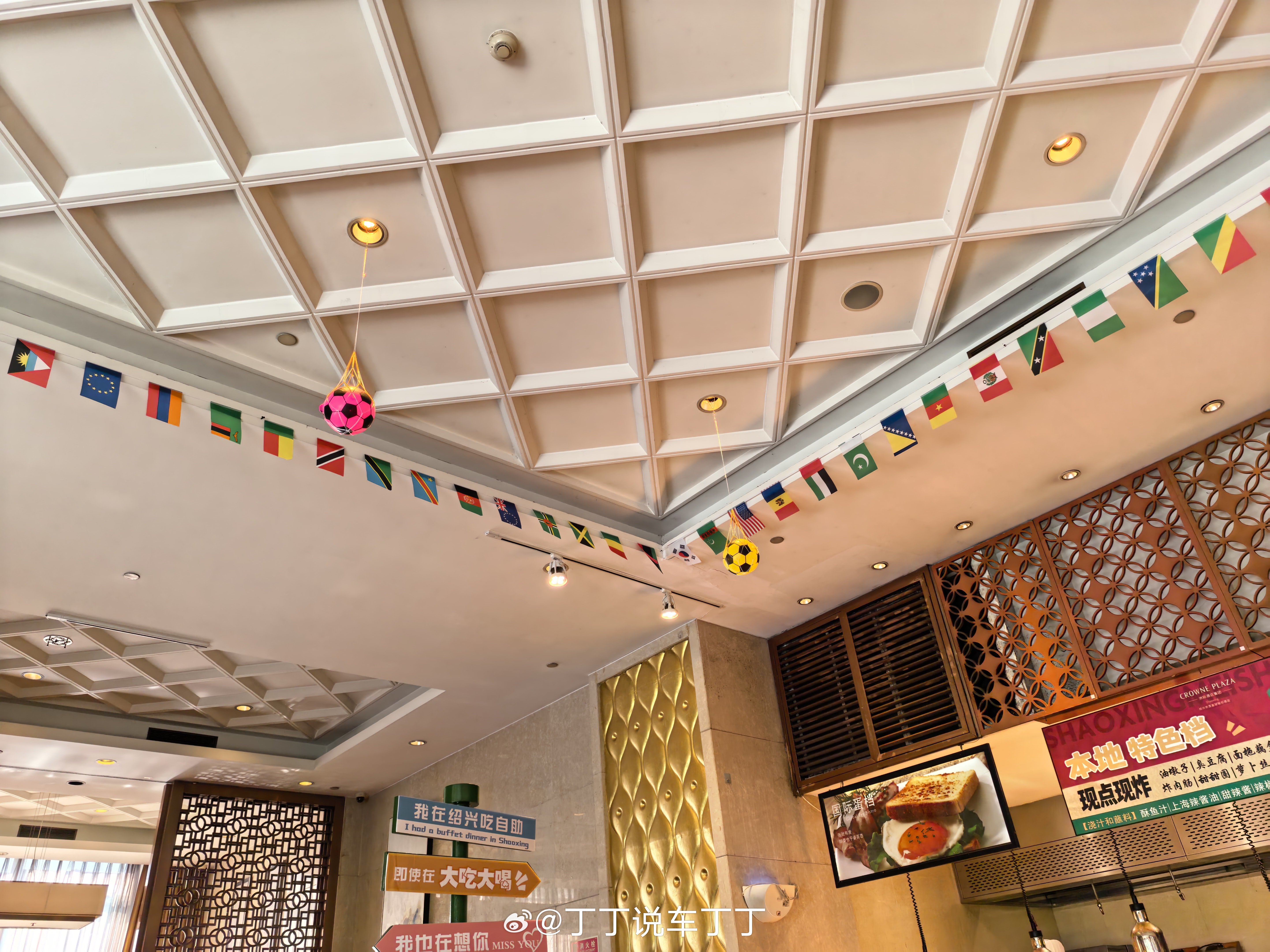 酒店早餐，餐厅里挂满了足球和国旗。娃问：为什么有这么多国旗和足球？我答：因为世界