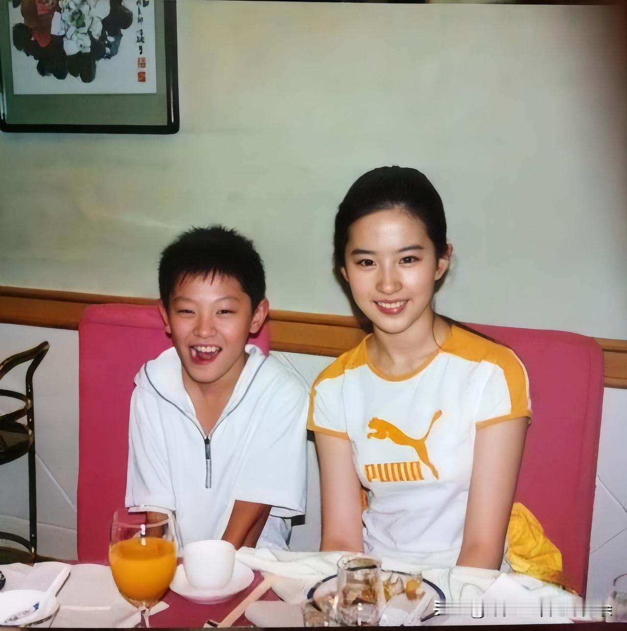 这是神仙姐姐刘亦菲刚出道不久与一名笑容开朗的小男孩餐厅室内的一张合影，拍摄于二零