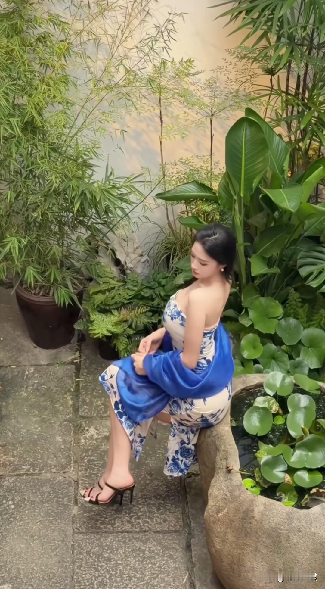 优雅蓝裙，静坐绿意中，享受宁静时光。
