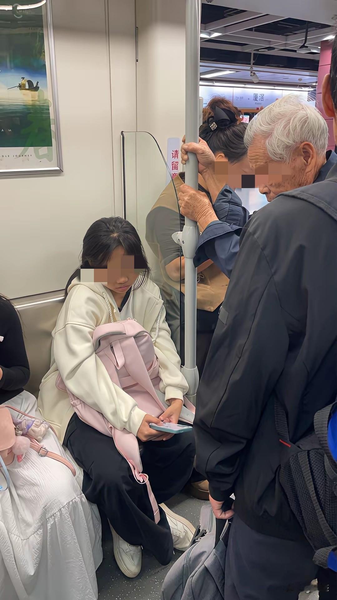 地铁里面两个年轻的女孩子，而前面站着一位年纪大的老爷爷。她们没有选择让座，而是低