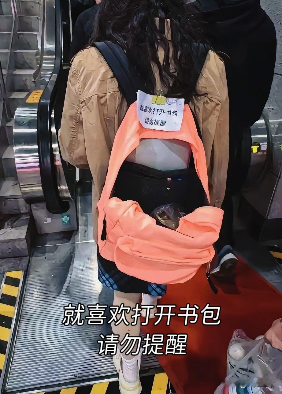上海地铁里，一个粉粉嫩嫩的书包成了新晋“网红”。
 
书包主人故意把背带反背，让