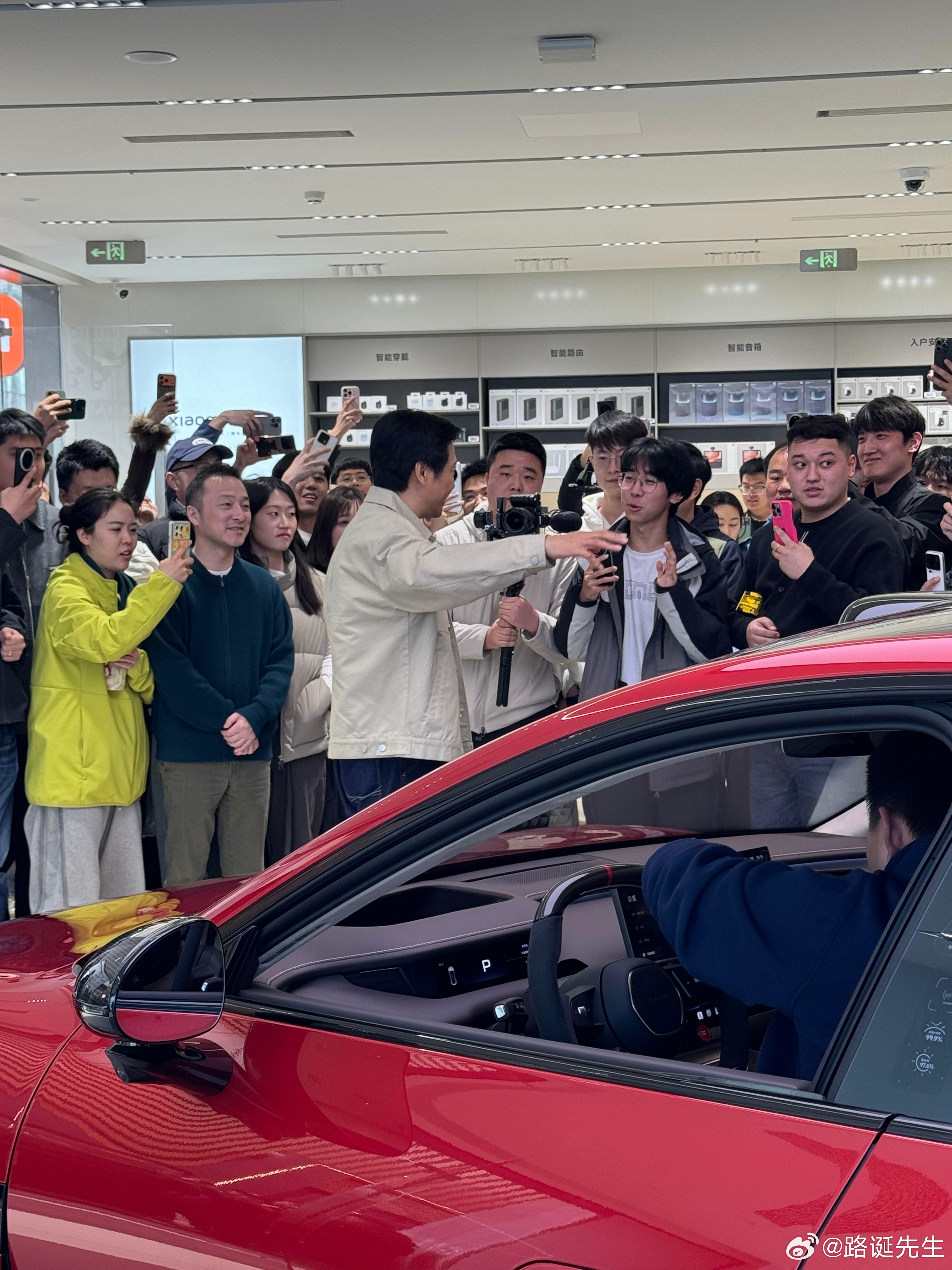 新SU7激发中国新能源车消费热雷军现身北京五棵松小米专卖店，可以看出门店现场非常