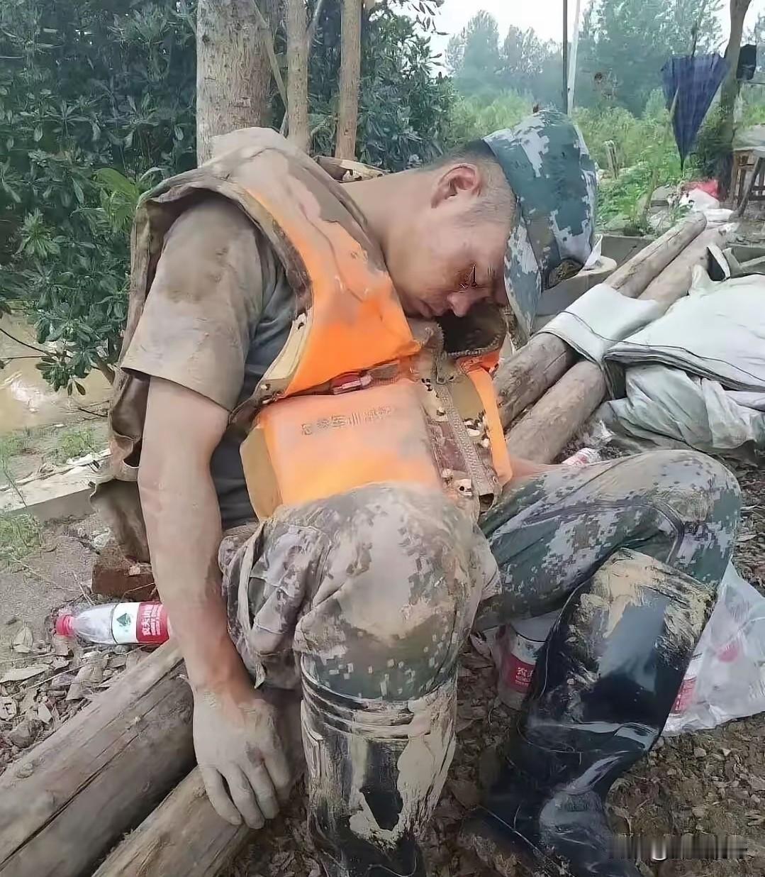 这一张定格在抗洪现场的照片，看过之后很多人不由得红了眼眶。满身黄泥的子弟兵战士，