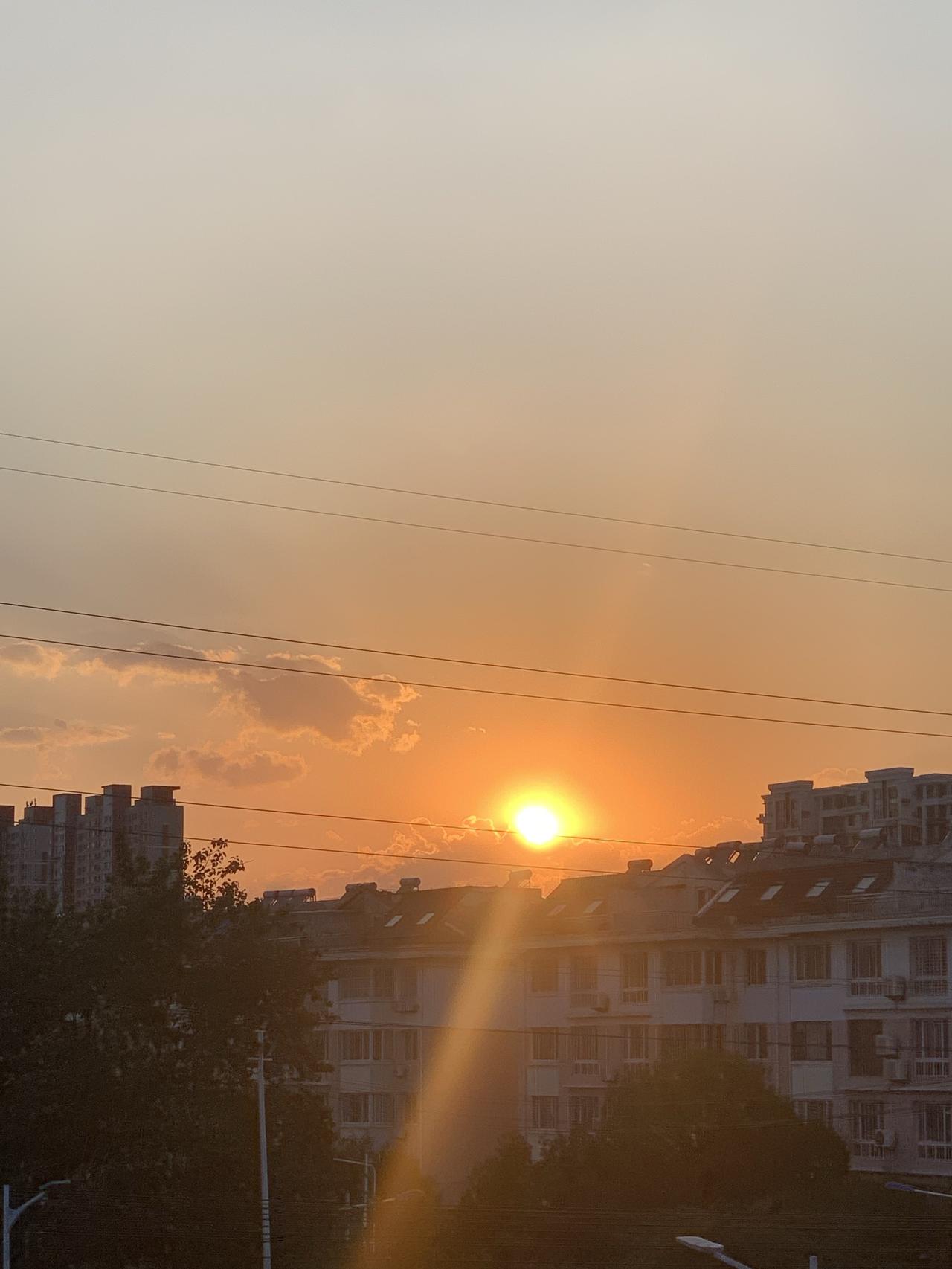 再看我家窗外的霞光。
这是今晚18点30分隔着我家玻璃窗拍下的夕阳，刚刚落下的那