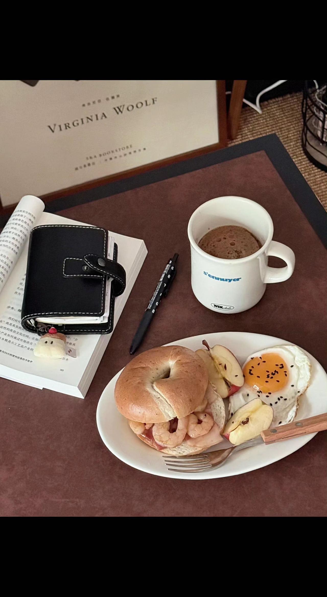 🌞晨光吻过贝果的褶皱，咖啡在杯中舒展成慵懒的云☕。文字与蛋香共舞，这片刻是生活