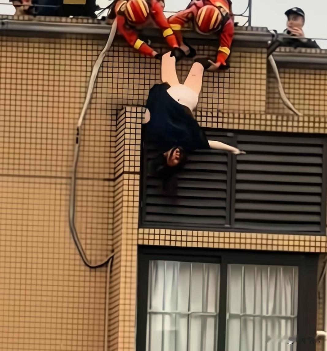看我们消防员为救这个女人，真是精神紧张费了好大劲，眼看都快拖上去的时候，这个要死