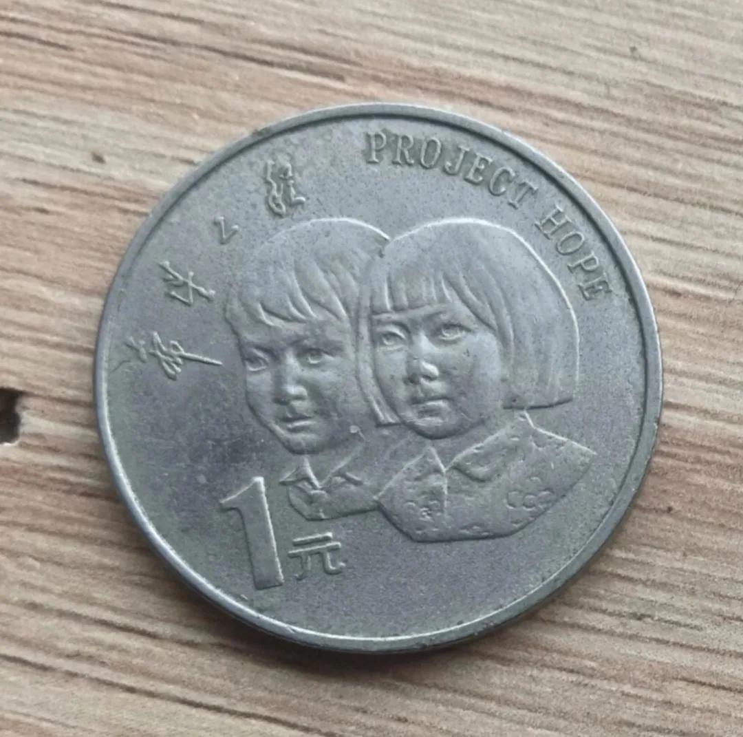 周末去公园，儿子在花坛里扣出来一枚硬币，回来洗干净发现上面有两个胖妞，还有一些英