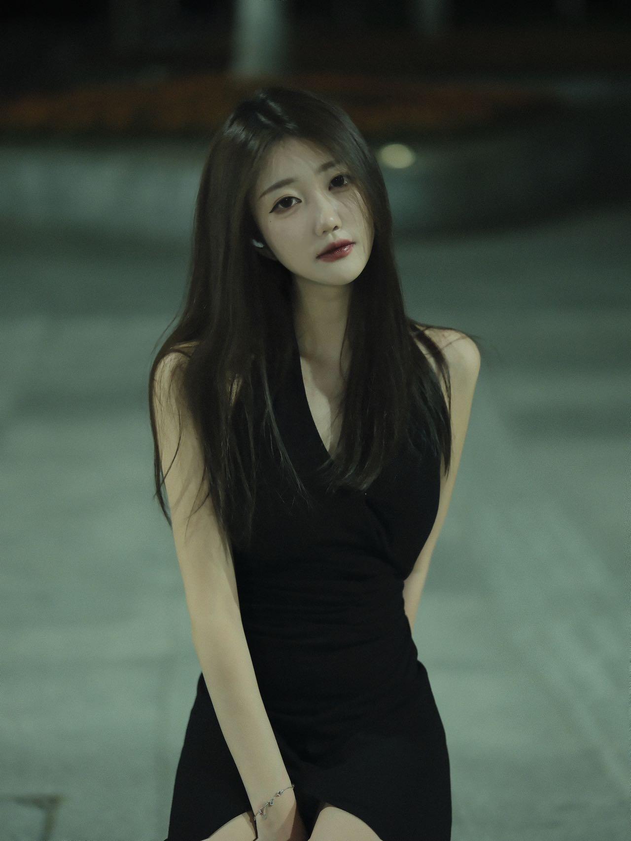 夜晚的神秘少女，黑色连衣裙，优雅而迷人。