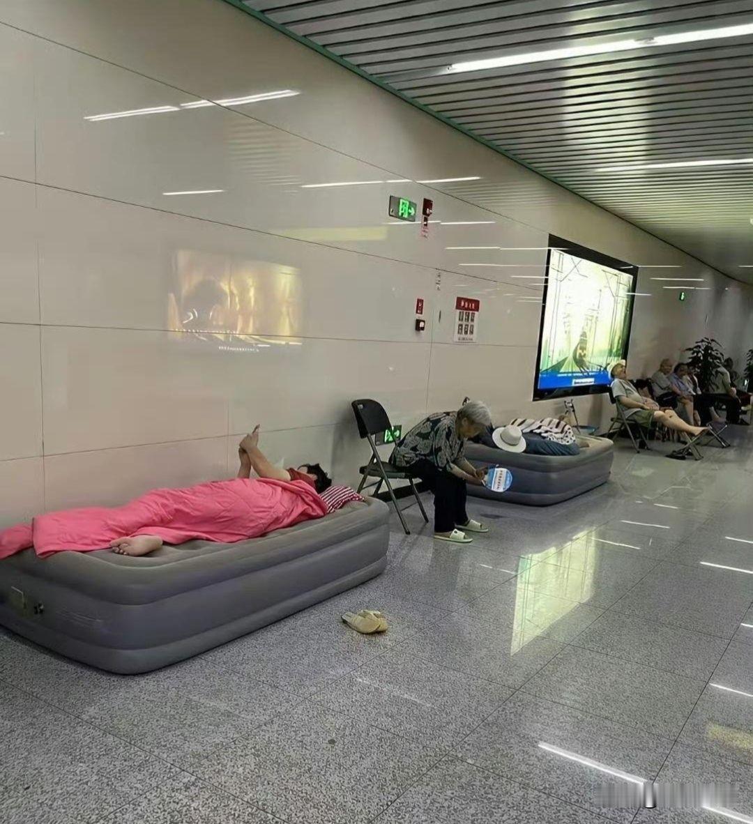 好家伙这下不去跳广场舞了，改去蹭地铁站空调了，只不过弄个被子睡在上面的有点不理解