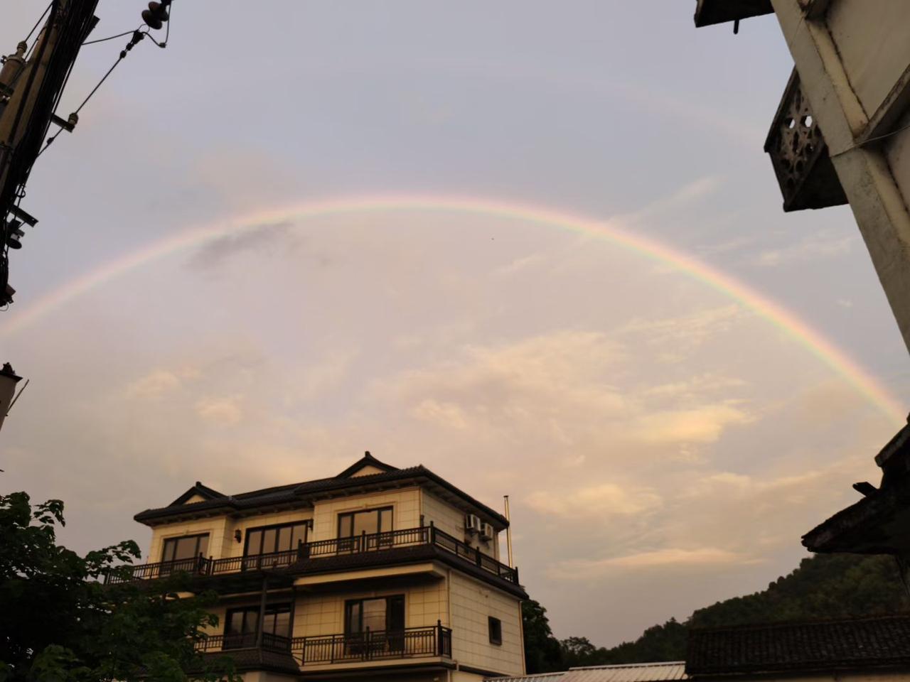 七绝·巷陌虹光
 
晚云轻染半村霞，
巷角新悬七彩纱。
檐下小楼凝静色，
一弯虹