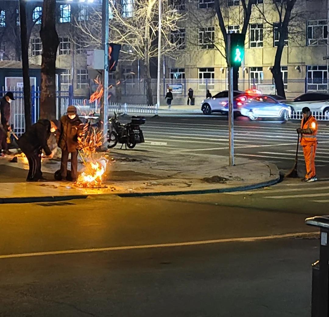 他们烧完了，他得扫到天亮
我就站在路口看了几分钟。
烧纸的人，点完火磕个头就走了