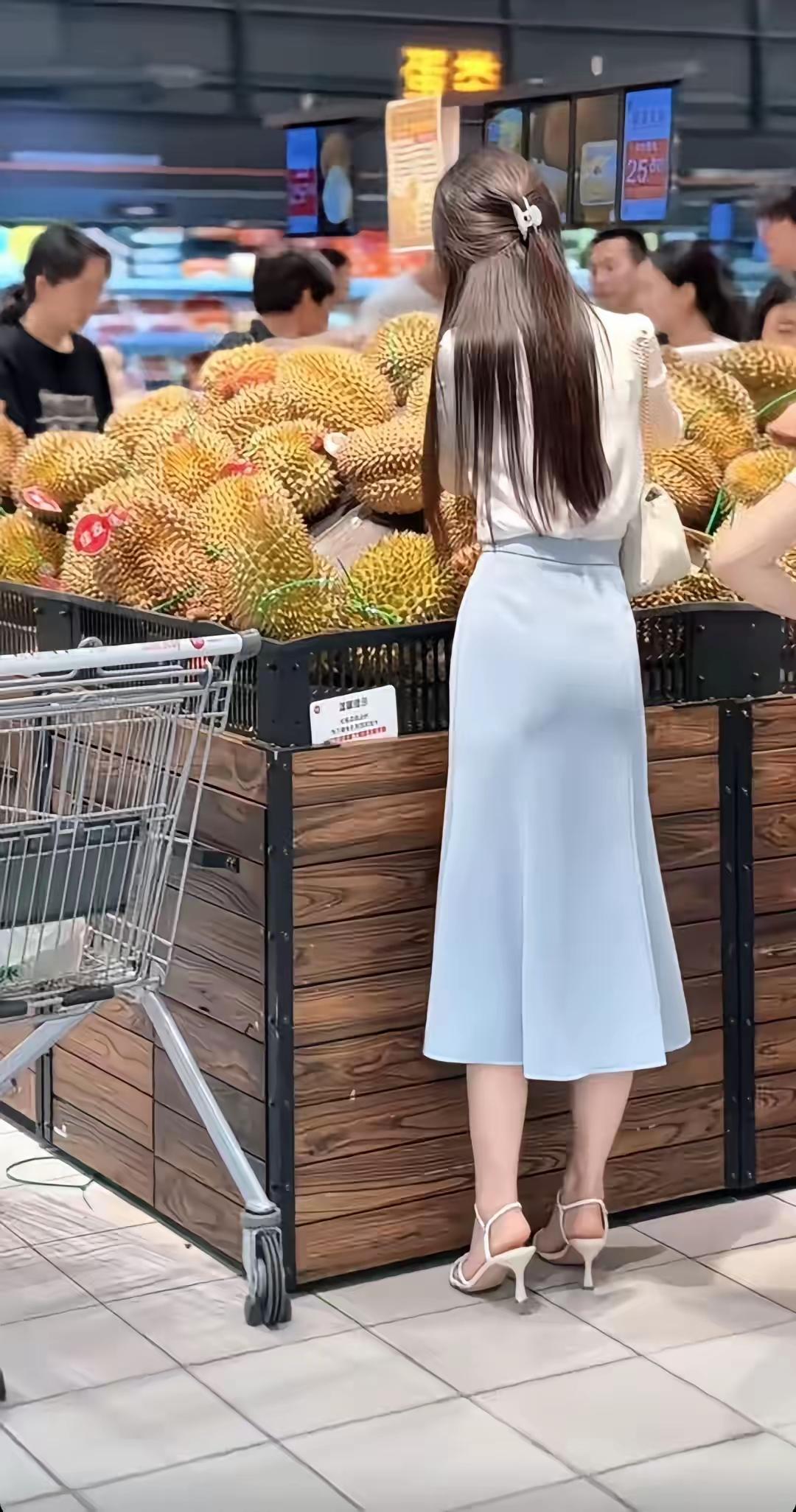 长发松松挽着一半，白衫干净利落，浅蓝鱼尾裙衬得身形温柔好看，细高跟添了几分精致。