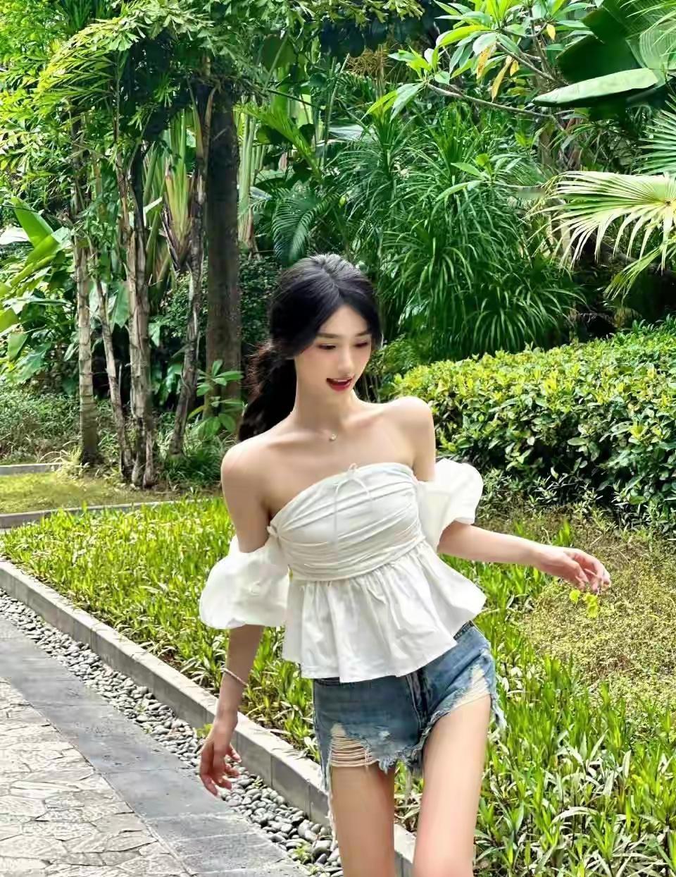 夏日清新穿搭，白色露肩上衣搭配牛仔短裤，漫步在绿意盎然的花园中。气质穿搭怎么穿才