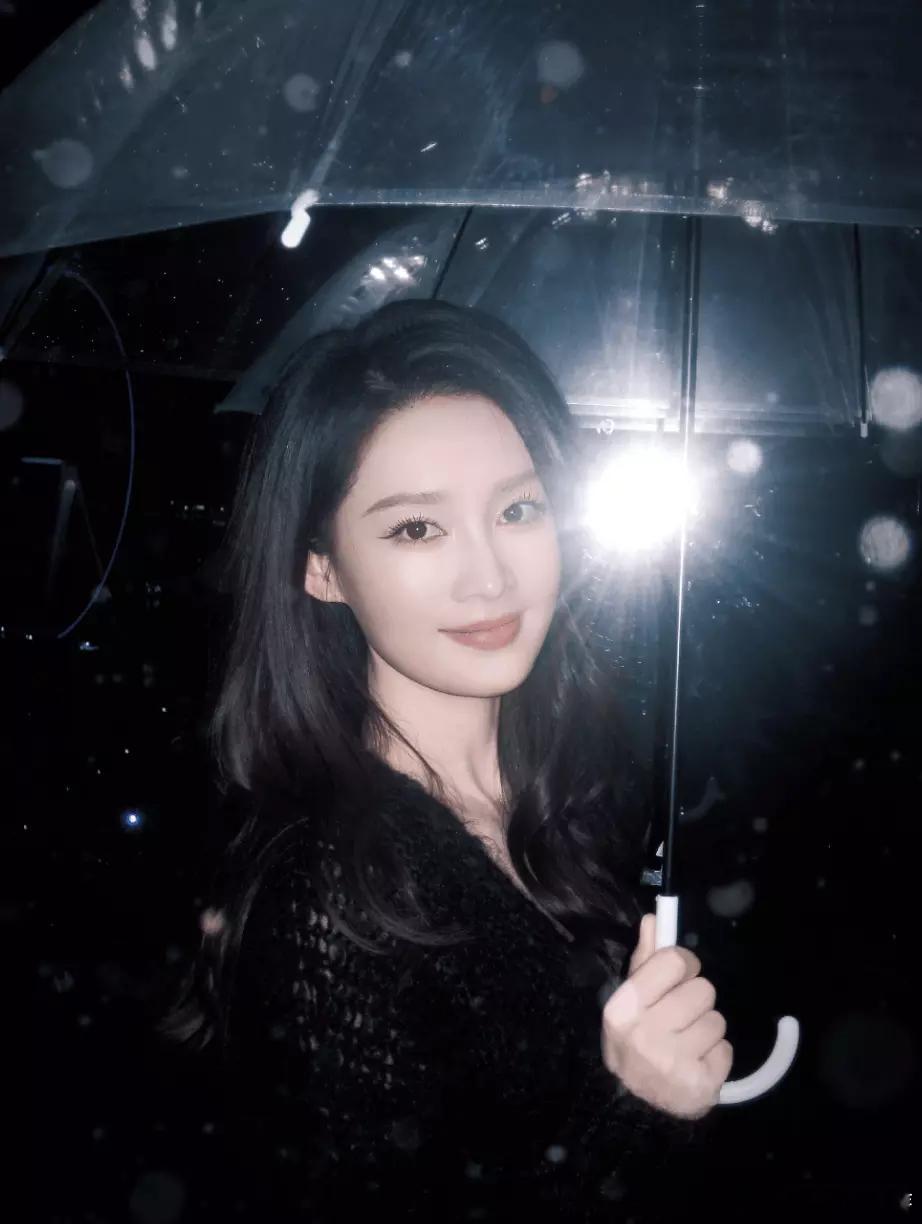 青青娱乐李沁雪夜撑伞神态柔和 眉眼温婉尽显冬日质感 
