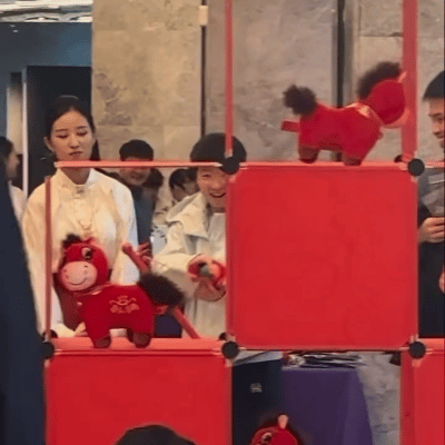 莎莎在玩游戏，周启豪在旁边一直笑。

重庆冠军赛的晚宴现场，莎莎在玩小马的游戏，