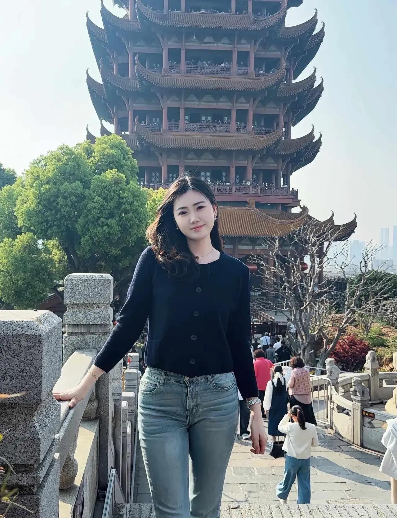 黄鹤楼前倩影
 
古楼高耸入云天，
翠树环绕景万千。
黑发轻扬眉目秀，
黑衣衫配