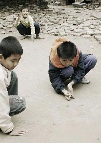 那时我们的快乐，简单得像一颗透明玻璃珠。

放学后的泥土地，几个小伙伴撅着屁股趴