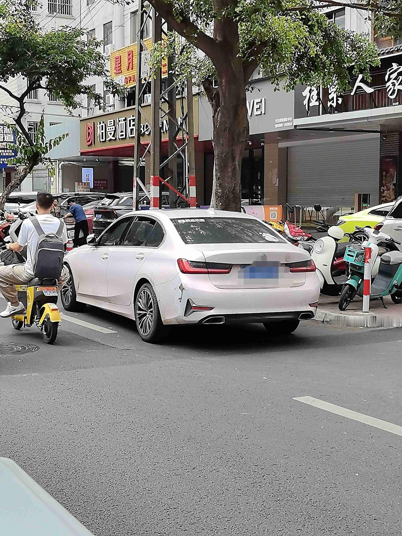 早高峰的街道，一辆白色宝马停在路口，一辆黑色宝马SUV一个不小心，就“亲”上了宝