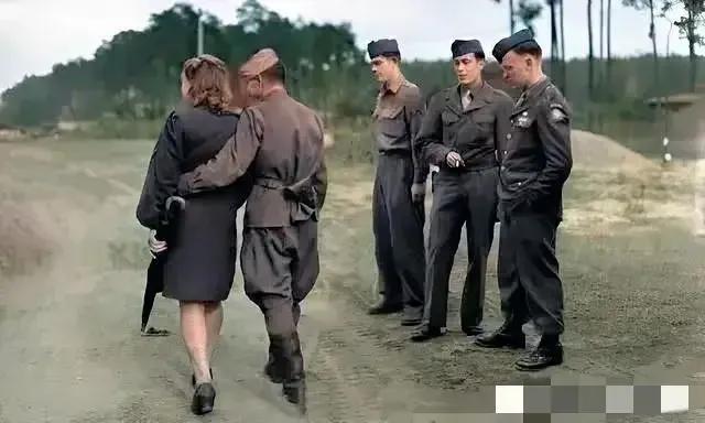 1945年，柏林街头，一名苏军士兵搂着一位迷人的德国情人走过，引起了路边三名美国