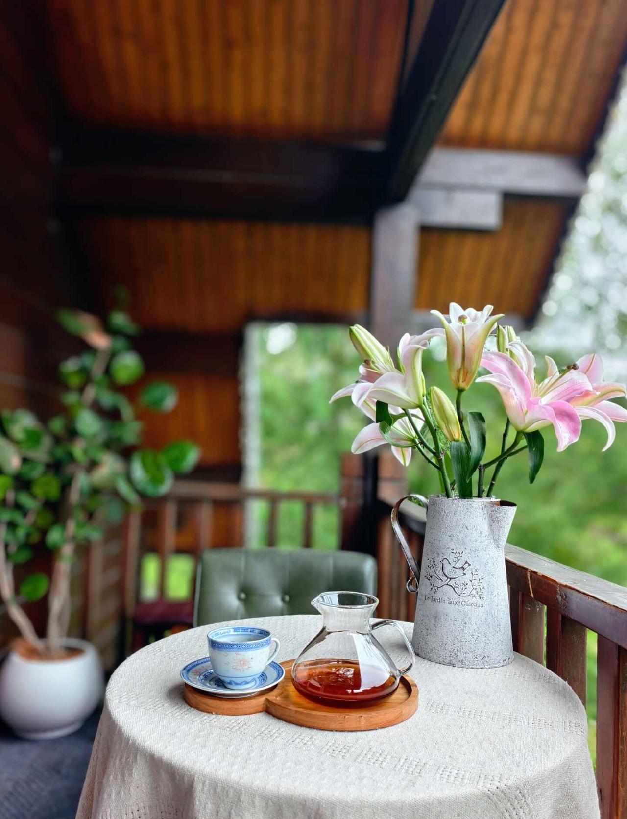 今天，是独享山野的下午茶☕️
木屋阳台的温柔时刻✨
一杯手冲，一束粉百合
风裹着