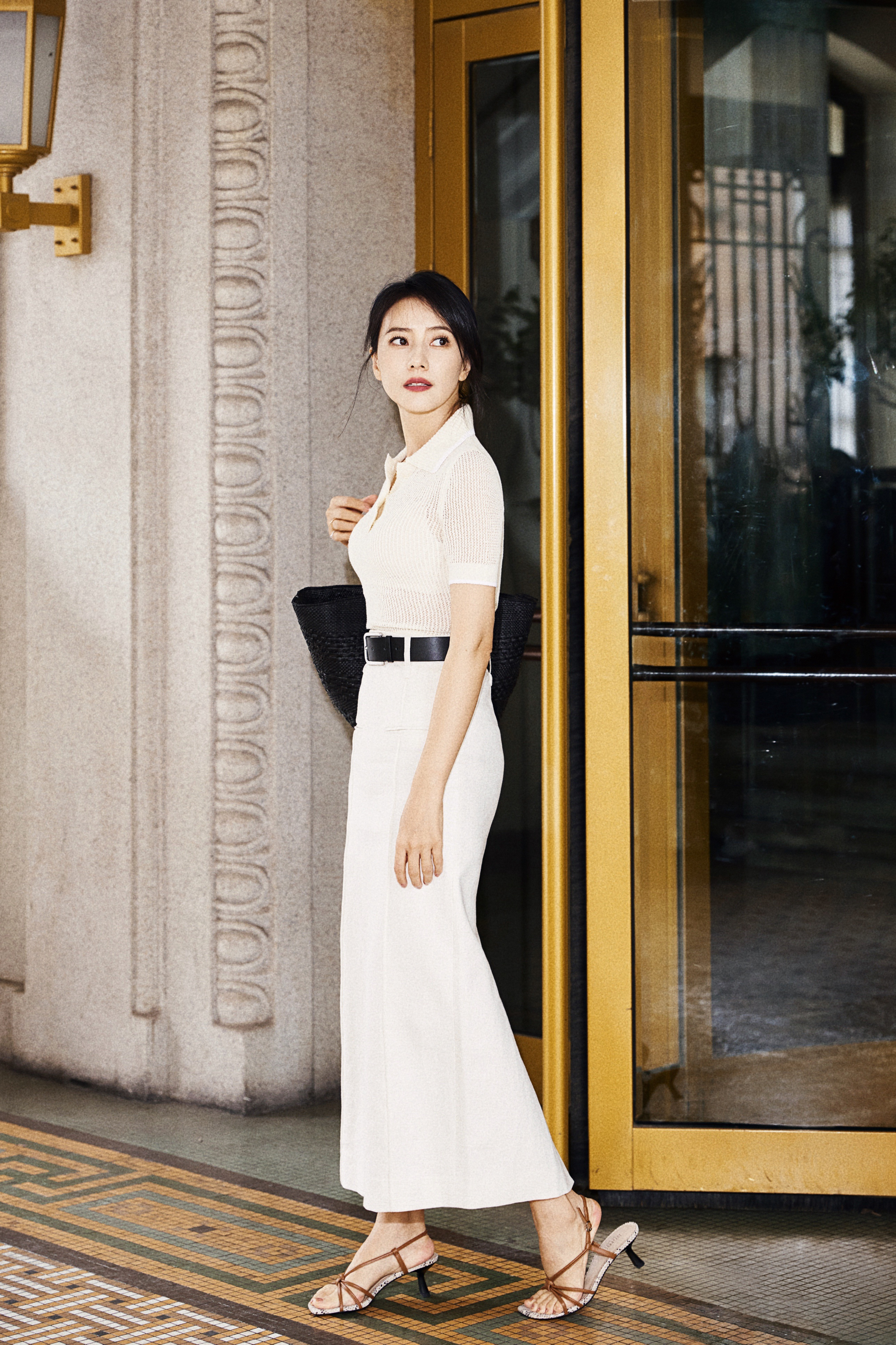 这组街拍大片将复古与摩登完美融合。米白色针织上衣与高腰鱼尾长裙的搭配，勾勒出优雅