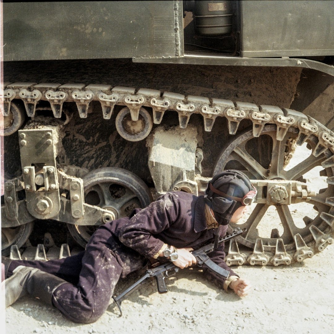 重演照片，还原坦克被击中起火后，两名坦克兵掩护受伤战友从车上撤离，一个车组通常配