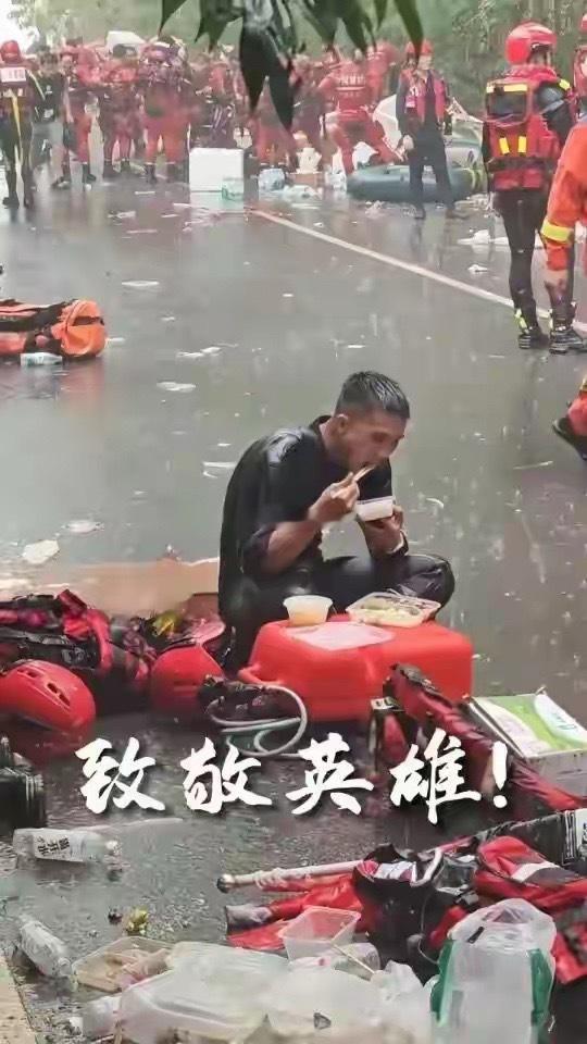 恕我直言！这张照片最戳人的不是雨中吃饭。而是不远处明明支着帐篷几步路就到，他就是